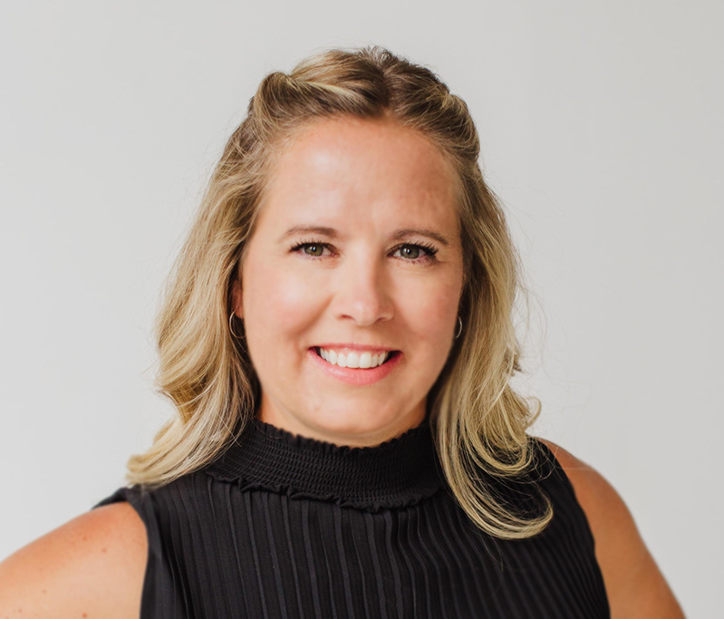 Kali Cortus QAFP. She is blonde and wearing a black sleeveless mockneck